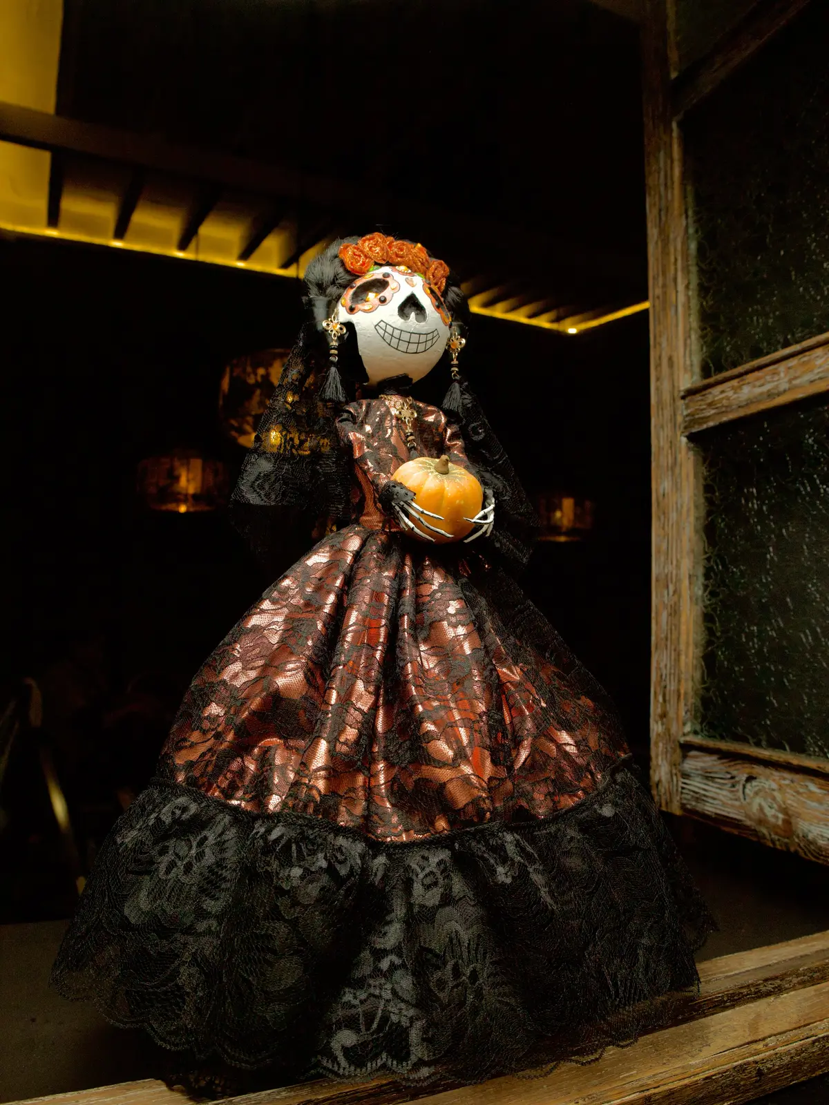 Catrina con vestido de encaje en un rincón de la casa