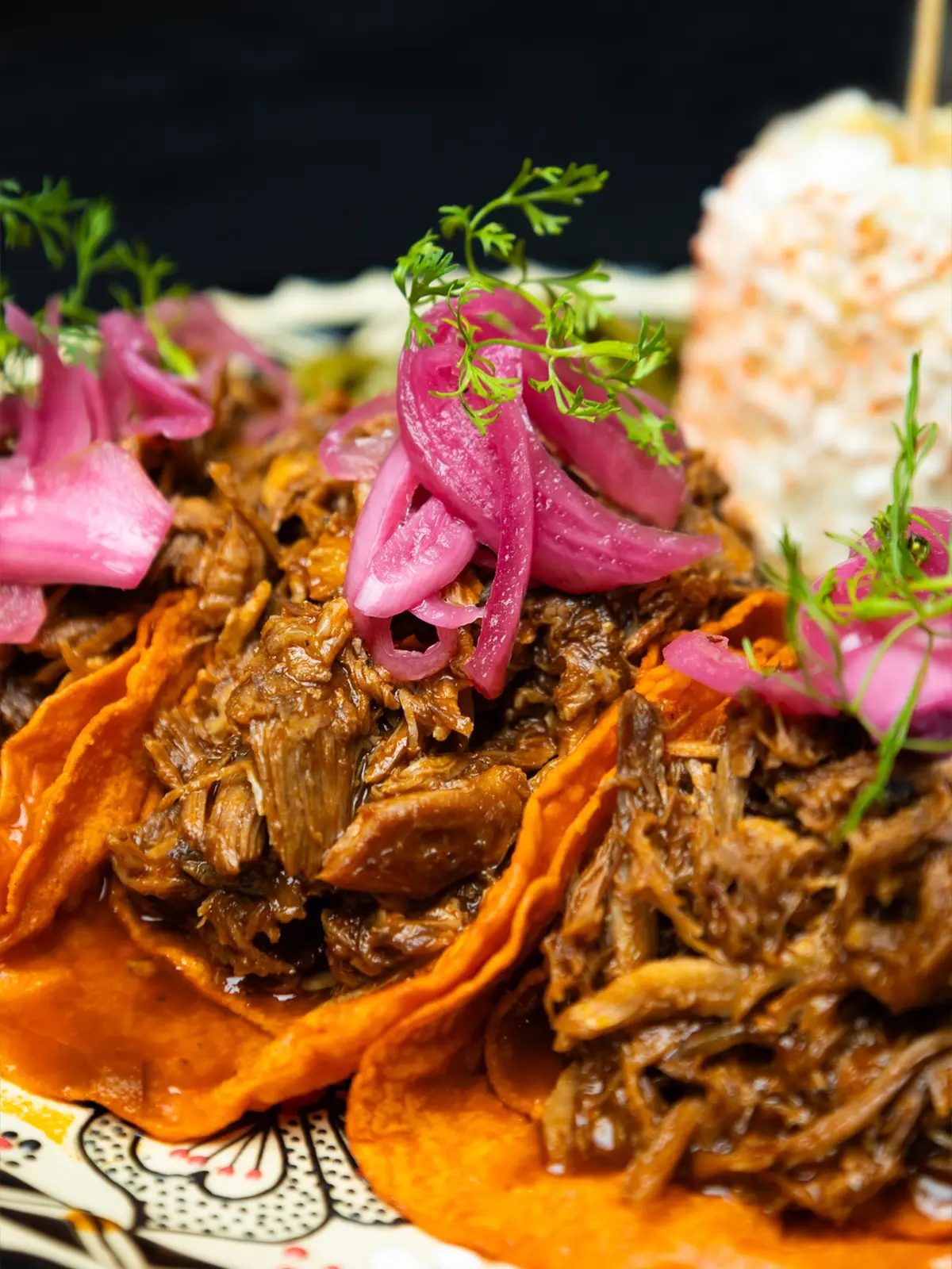 Tacos con carne deshebrada y cebolla morada encurtida